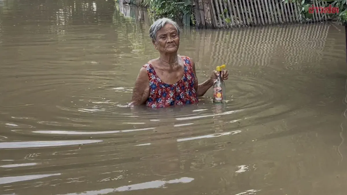 Elderly Woman Wades Flood Waters for Fish Sauce